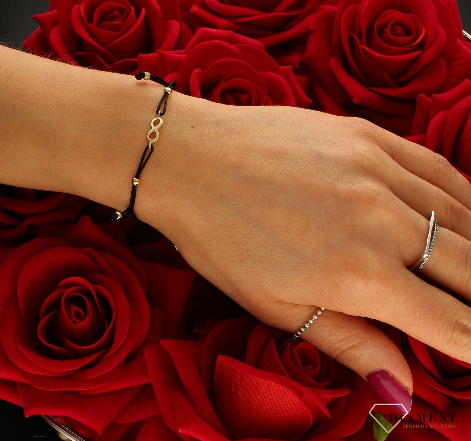 Złota bransoletka damska na sznureczku 'Nieskończoność' BR 1886A 585.  Bransoletka na czarnym sznureczku ozdobiona złotymi kulkami oraz znakiem nieskończoność. Kuleczki i zawieszka wykonane są z najwyższej jakości złota prób.jpg